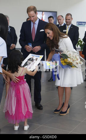 The Duke and Duchess of Cambridge speak with four-year-old Maeve Low during a visit to a Rolls-Royce factory in Singapore, as part of a nine-day tour of the Far East and South Pacific in honour of the Queen's Diamond Jubilee. Stock Photo