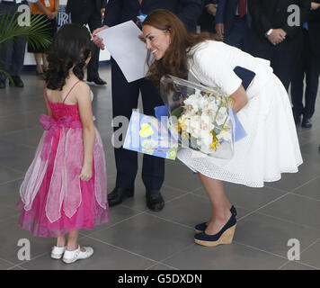 The Duchess of Cambridge speaks with four-year-old Maeve Low during a visit to a Rolls-Royce factory in Singapore, as part of a nine-day tour of the Far East and South Pacific, with the Duke of Cambridge, in honour of the Queen's Diamond Jubilee. Stock Photo