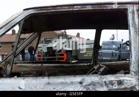 The remains of a burnt out car, on the Ardoyne Road, North Belfast, after a second night of rioting 2001. Around 50 petrol bombs, paint bombs and heavy missile attacks were launched at riot police. * ..drafted into the Ardoyne area which has been the focus for much of the trouble. Stock Photo