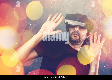 Scared adult man wearing virtual reality goggles and enjoying in scary 3D VR multimedia content Stock Photo
