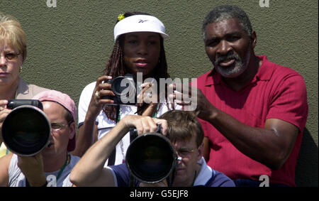 NO COMMERCIAL USE : Venus Williams (centre) with father Richard Williams watches her sister Serena during her First Round match of the 2001 Lawn Tennis Championships at Wimbledon, London. Stock Photo