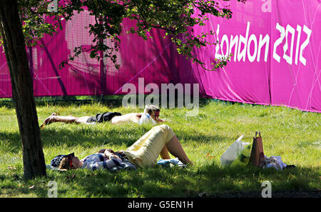 People relax during the warm weather in St James' Park, London. Stock Photo