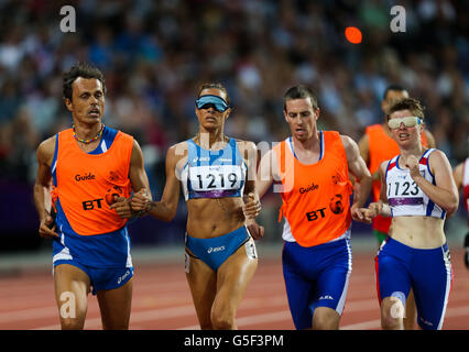 Italy's Annalisa Minetti runs alongside her guide Andrea Giocondi ahead of the Czech Republic's Miroslava Sedlackova and her guide Michael Prochazka in the women's 1500m T12 in the Olympic Stadium. Stock Photo