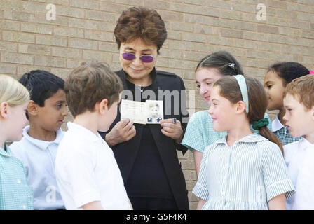 Musician and artist Yoko Ono, widow of Beatles singer John Lennon, shows a picture of her late husband to the children at Dovedale School in Liverpool. She visited the school which was attended by her late husband when he was a youngster in Liverpool. Stock Photo