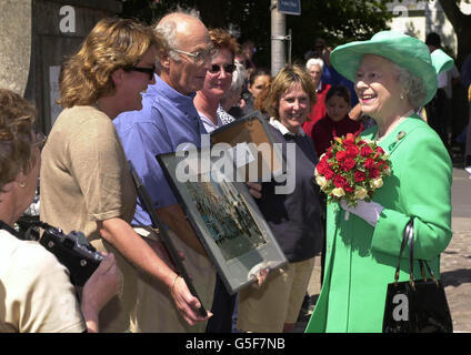 Britain's Queen Elizabeth II is shown images of her last visit to Alderney, in 1989, by Mr Ian Waterfall on the island of Alderney, on the first day of her two day svisit to the Channel Islands. Stock Photo