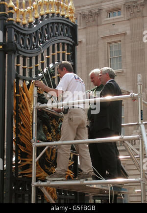 Engineers examine damage caused to the gates of Buckingham Palace - the official London residence of Britain's Queen Elizabeth II - caused by a lorry that reversed into them, when it was leaving after collecting marquees used for the summer garden parties. * Earlier, on the way in, the articulated lorry hit a stone gateway at the Queen's Garden Entrance, causing structural damage. Stock Photo
