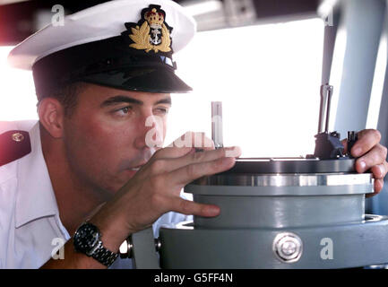 Royal Naval Lieutenant Angus Essenhigh takes a bearing on the bridge of the United States Navy's newest warship the USS Winston S. Churchill in Portsmouth, on the ship's maiden overseas visit. *... Named after Britain's wartime prime minister she is the only US ship to have a permanent Royal Naval officer aboard. Lieutenant Essenhigh RN is the ship's navigator and the son of Admiral Sir Nigel Essenhigh. The ship was escourted into Porstmouth by Motor Torpedo Boat 102 which was used by Churchill and General Eisenhower to inspect the D-Day invasion fleet. Stock Photo