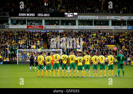 Fans observe a minutes applause in memory of former Norwich City manager John Bond before the match Stock Photo