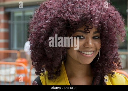 Portrait of a beautiful college student with a larger purple Afro hairdo. In Greenwich Village, New York City. Stock Photo