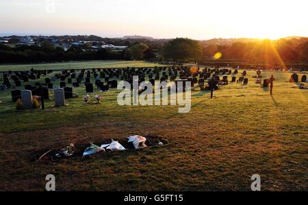 A general view showing flowers left on the grave of Sir Jimmy Savile in Woodlands Cemetery, Scarborough, where the headstone was removed overnight at the request of Savile's family. Stock Photo