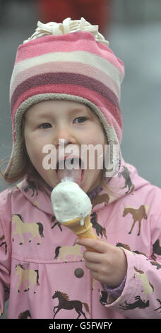 Emily Condan (4) from Rathangan enjoys an ice cream on a wet day during the Hacketts Bookmakers Irish Cesarewitch/Staffordstown Stud Stakes at Curragh Racecourse, Curragh. Stock Photo