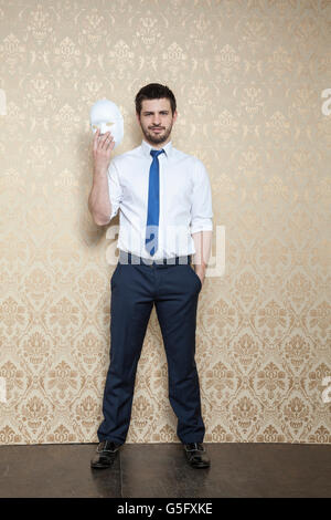 Smiling businessman took off his mask Stock Photo