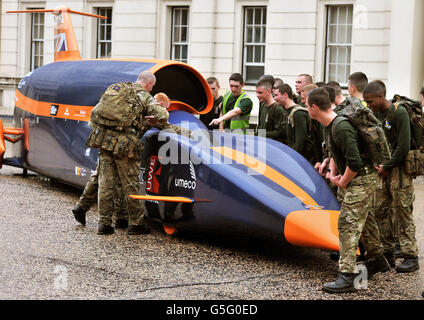 A group of soldiers from the Scottish Guards admire the Bloodhound Project jet engine and hybrid rocket motor powered car, at the Wellington barracks in central London, as Defence Minister Philip Dunne announced MoD involvement for the Bloodhound Project. Stock Photo