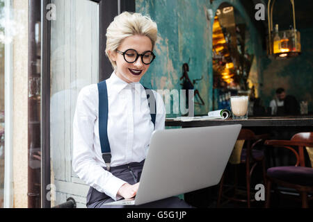 Portrait of a young beautiful businesswomen enjoying coffee during work on portable laptop computer Stock Photo