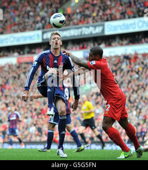 Stoke City's Peter Crouch battles for the ball with Liverpool's Glen Johnson (right) during the Barclays Premier League match at Anfield, Liverpool. Stock Photo