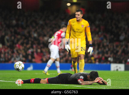 Olympiakos' Ricardo Paulo Machado lays on the ground dejected after missing a shot while Arsenal goalkeeper Vito Mannone looks on Stock Photo
