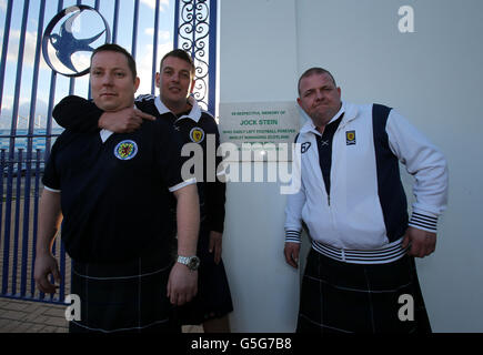 Scotland fan Gordon Young and friends Graham and Tony at the old Ninian Park Gates with the plaque in memory of former Scotland Manager Jock Stein prior to the 2014 FIFA World Cup Qualifying match at Cardiff City Stadium, Cardiff. Stock Photo