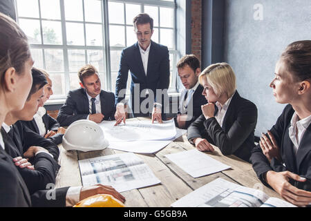 Business people group on meeting with construction engineer architect looking building blueprint Stock Photo