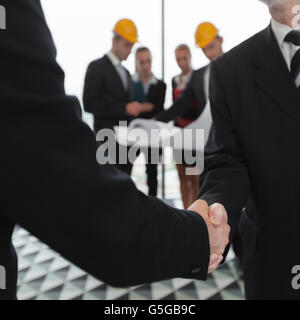Handshake of architect and investor, business team with blueprint on background Stock Photo