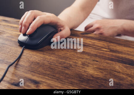 Woman using computer mouse, selective focus on female hand and pointing device on office desk Stock Photo