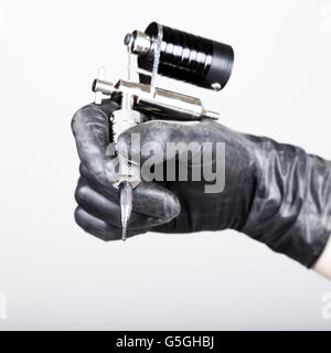 close-up of Tattooist hands in black gloves with tattoo machine Stock Photo