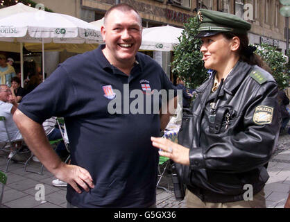 England fan Dave Malan jokes with a German police officer on patrol in the centre of Munich before the England v Germany football match. In England, police are attempting to stop known troublemakers from travelling to England's World Cup qualifying match. * against Germany in an attempt to stop trouble in Munich. Stock Photo