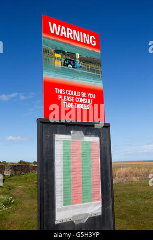 UK, England Northumberland, Lindisfarne, Holy Island, causeway crossing times warning sign Stock Photo