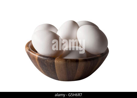 A wooden bowl with white chicken eggs isolated on white. Stock Photo