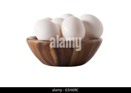 Side view of a wooden bowl with white chicken eggs isolated on white. Stock Photo