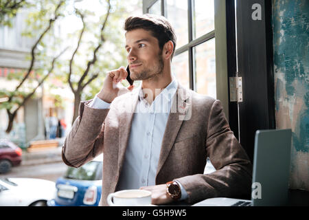 Young handsome businessman making phone call in cafe indoors Stock Photo