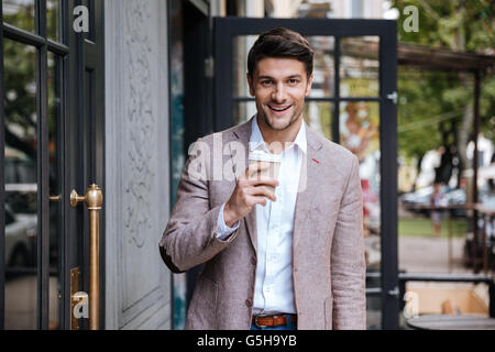 Young business man drinking a cup of coffee outdoors at cafe Stock Photo
