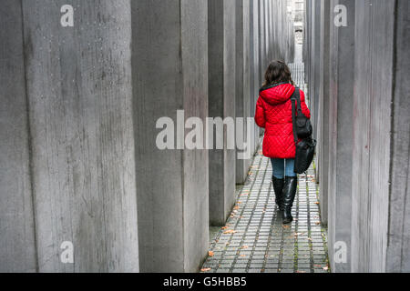 Woman in a red coat at the Memorial to the Murdered Jews of Europe or Holocaust Memorial, Berlin, Germany Stock Photo