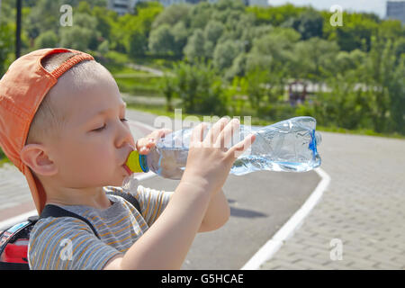 Child drinking pure water in a park Stock Photo