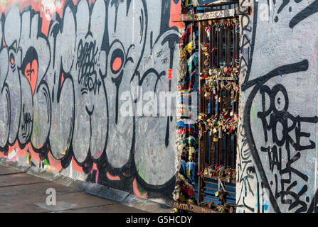 Sections of the Berlin Wall, now covered in street art and lovelocks at the East Side Gallery in Berlin, Germany Stock Photo