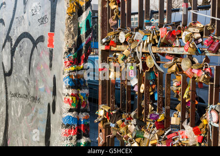 Sections of the Berlin Wall, now covered in street art and lovelocks at the East Side Gallery in Berlin, Germany Stock Photo