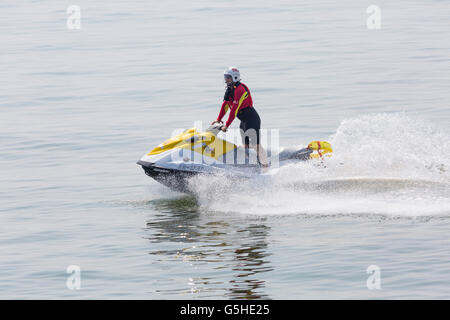 RNLI Lifeguard riding on jetski at Bournemouth beach, Bournemouth, Dorset UK on a hot sunny day in June Stock Photo