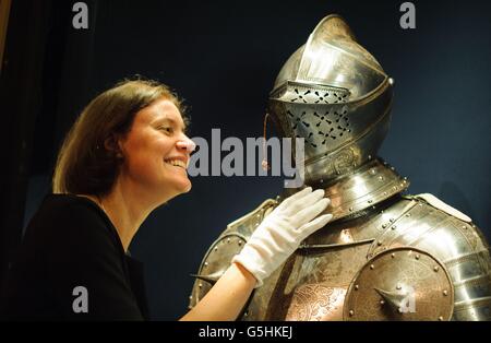 Exhibition Curator Kate Heard adjusts a suit of armour dating from around 1563, part of 'The Northern Renaissance: Durer to Holbein' exhibition, at the Queen's Gallery, in central London, which will run from 2 November 2012 to 14 April 2013. Stock Photo
