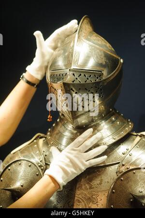 Exhibition Curator Kate Heard adjusts a suit of armour dating from around 1563, part of 'The Northern Renaissance: Durer to Holbein' exhibition, at the Queen's Gallery, in central London, which will run from 2 November 2012 to 14 April 2013. Stock Photo