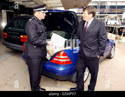 Home Office Minister Bob Ainsworth and Assistant Chief Constable Chris Sims with some of the property seized from drug dealers in the West Midlands area, including a Mercedes sports car, Range Rover and quantiies of Drugs and money. * The Minister was visiting West Midlands Police Headquarters during the launch of the 'Proceeds of Crime ' bill presently being debated in Parliament. Stock Photo