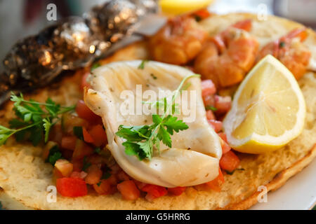 Grilled squid and shrimps with salsa on toast closeup Stock Photo