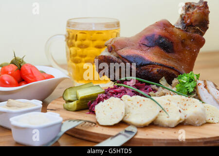 Baked pork shank and sauerkraut closeup on a plate and beer on the table. horizontal Stock Photo