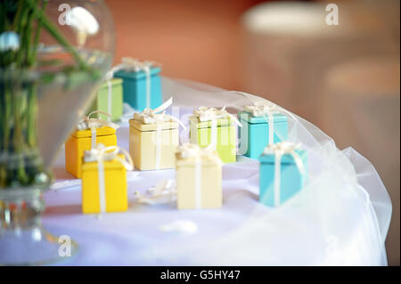 Brightly colorful little party favors in the form of decorative gift boxes Stock Photo