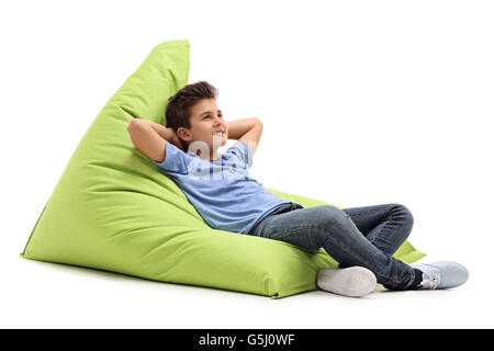 Relaxed boy laying on a comfortable green beanbag isolated on white background Stock Photo