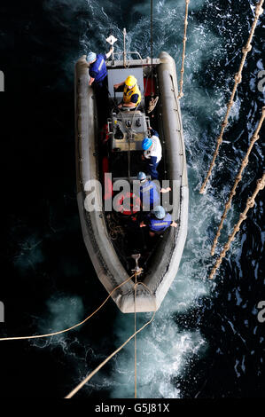 Sailors conduct a man overboard drill in a rigid-hull inflatable boat. Stock Photo