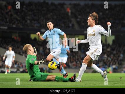 Manchester City's goalkeeper Joe Hart saves a shot from Swansea City's Miguel Michu (right) Stock Photo