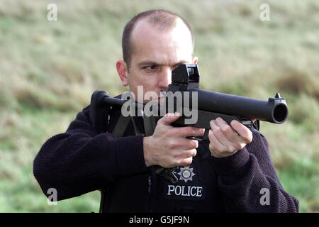 Pc Mick Pinsent from the Firearms Unit of Bedfordshire. Police gives a demonstration of the new Heckler Koch baton gun in Cardington, Bedford. * ...... Bedfordshire will be the first force in the country to use a new style baton gun similar to weaponry used by police in Northern Ireland. It is the first time police in mainland UK will have carried weapons which are less lethal than ordinary firearms, but more powerful than CS Spray. Stock Photo