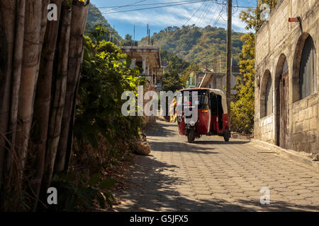 A motocar taxi navigates the streets of San Pedro La Laguna in Lake Atitlan Guatemala, a popular tourist destination. Stock Photo