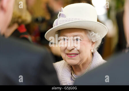 Queen Elizabeth II meets members of staff at The Poppy Factory as she viewed the making the red emblem of the British Legion's annual poppy appeal, during a visit to the company headquarters in Richmond, London. Stock Photo