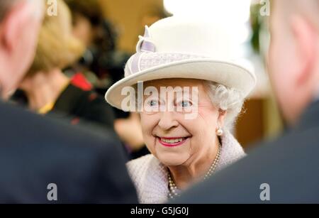 Queen Elizabeth II meets members of staff at The Poppy Factory as she viewed the making the red emblem of the British Legion's annual poppy appeal, during a visit to the company headquarters in Richmond, London. Stock Photo