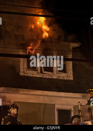 Chappaqua, NY - April 11, 2014: Firefighters from Chappaqua and several surrounding towns in Westchester County New York fight a blaze in a building that houses the Whispering Pines Flower Shop and residential apartments in Chappaqua, NY. The fire began around 1 AM Friday morning and as dawn broke the fire was still going, with heavy smoke blanketing the surrounding area. © 2014 Marianne A. Campolongo Stock Photo